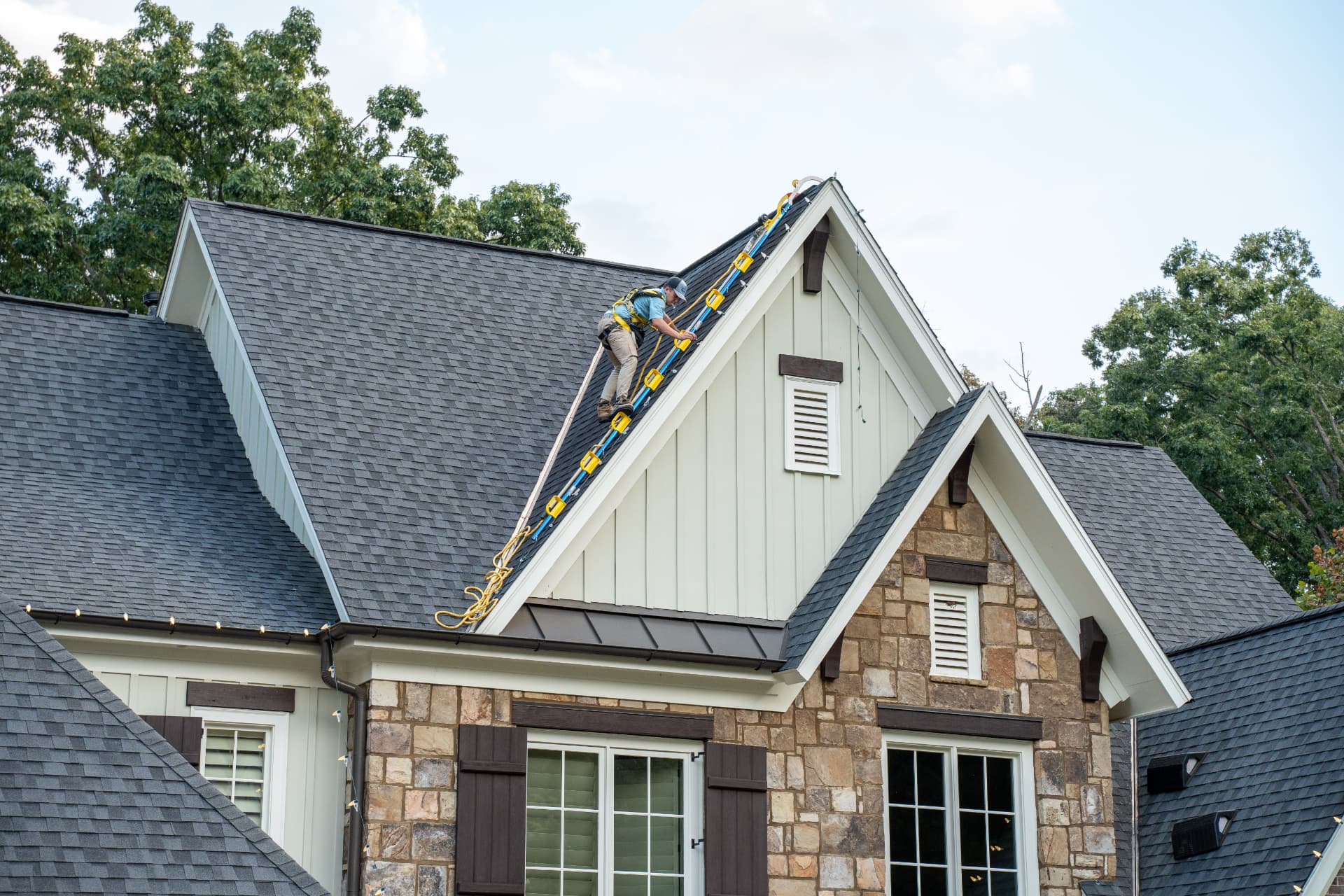 Installer working safely on a steep roof with fall protection